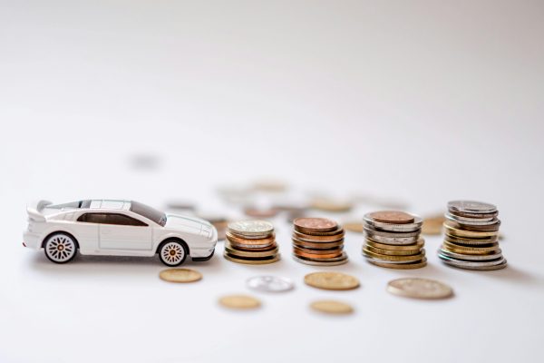 white toy car and stacks of coins