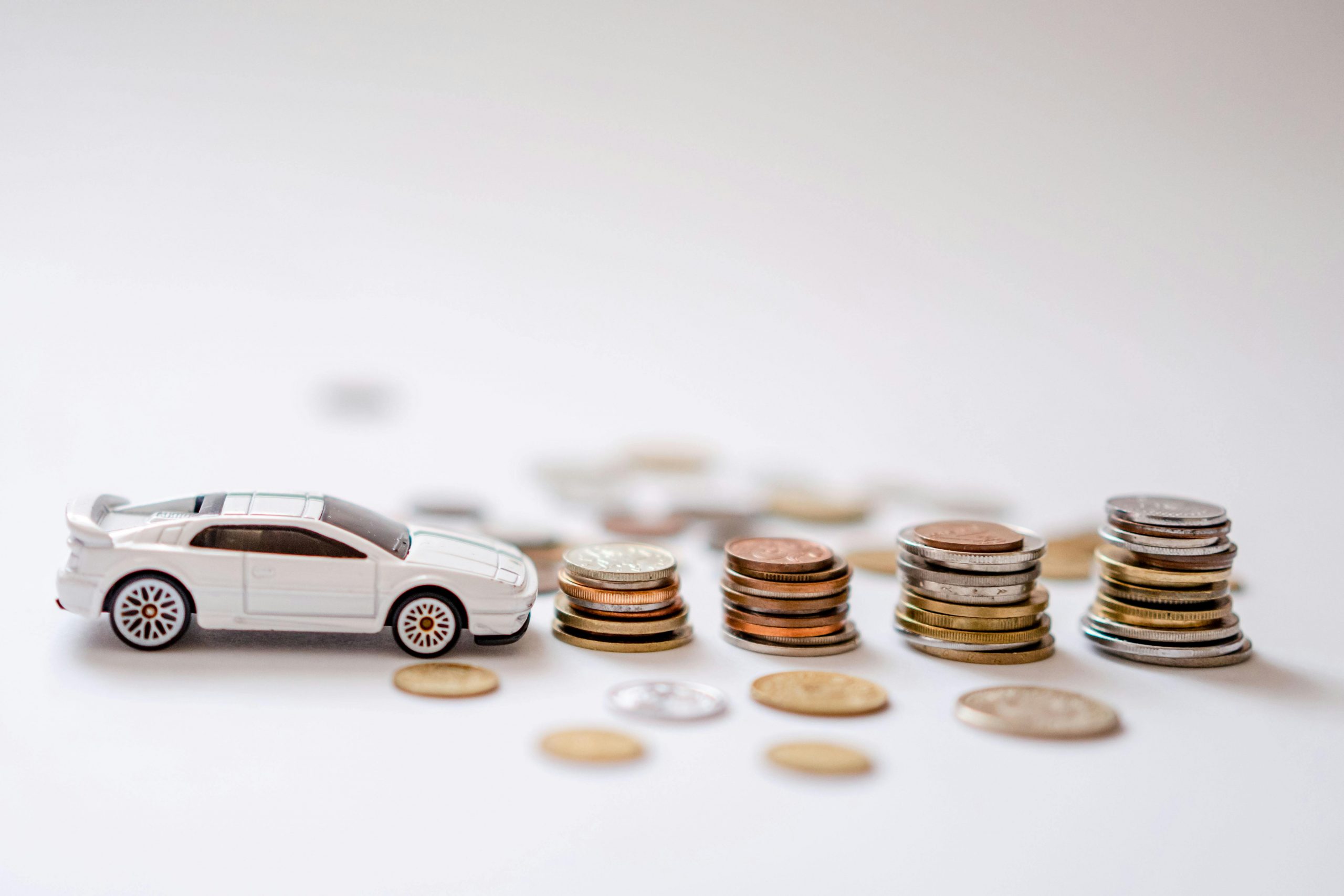 white toy car and stacks of coins